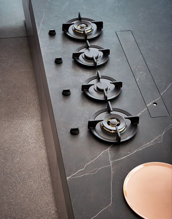 Gas hob detail set into a honed stone worktop