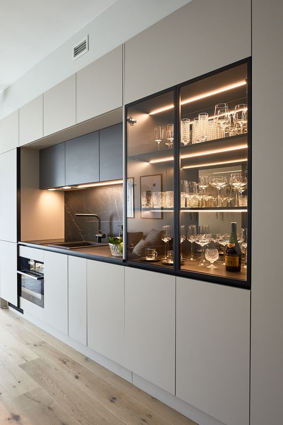 Framed glass cabinetry with warm interior lighting